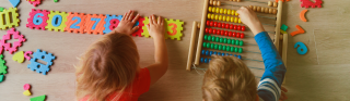 Two young children play with number blocks and an abacus.