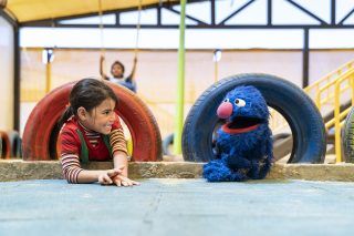 Grover on a playground with a kid.