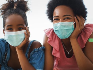 A mother and daughter wearing protective masks together.