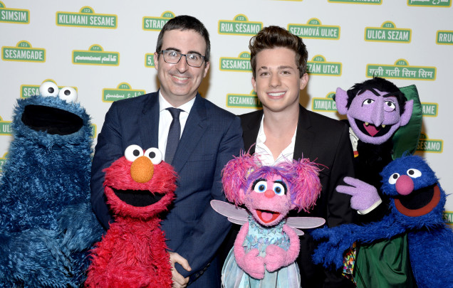 John Oliver and Charlie Puth pose with Cookie Monster, Elmo, Abby, the Count, and Grover.