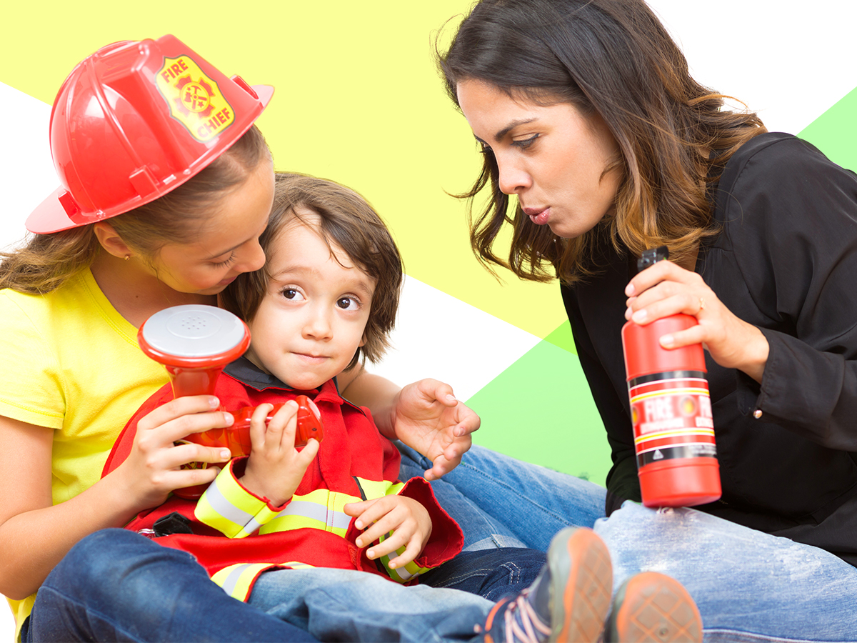 A parent plays with her children dressed like firefighters