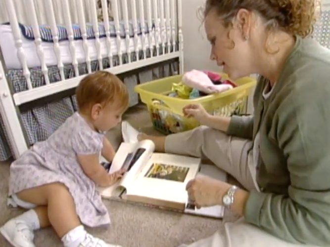 A parent reading to her toddler.