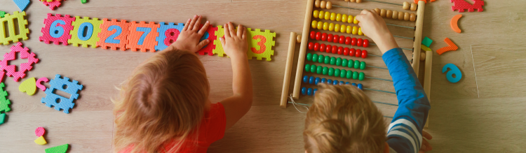 Two young children play with number blocks and an abacus.