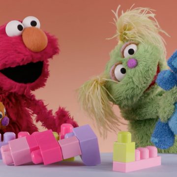 Karlie and Elmo playing with blocks.