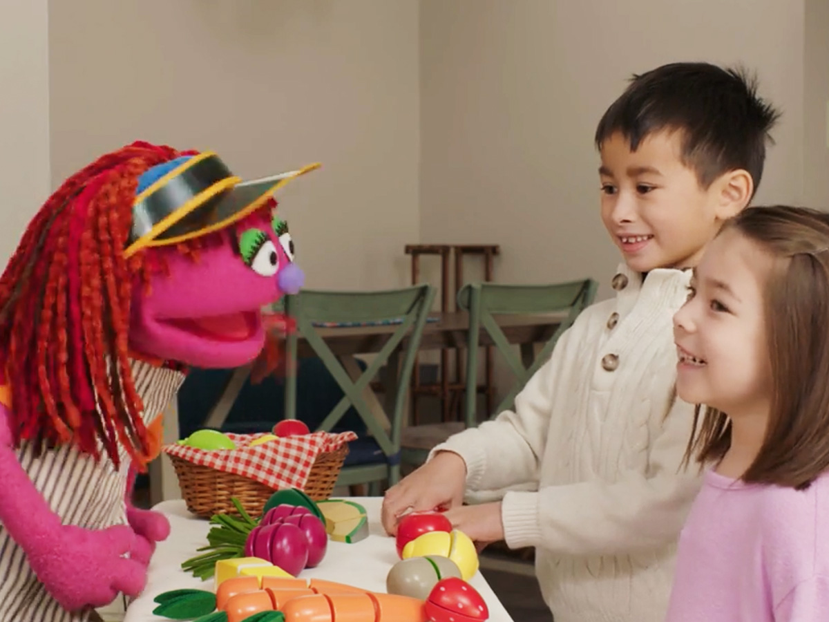 Lily playing market with two children.