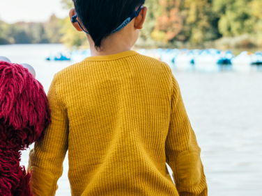 Elmo and child looking at a lake.