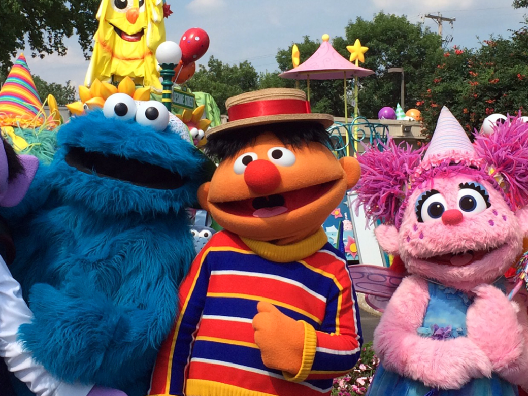 A group of Sesame Street Muppets pose together during a parade.