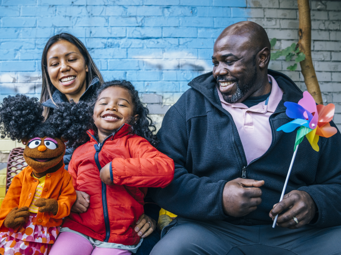 Gabrielle poses with two grownups and a child.