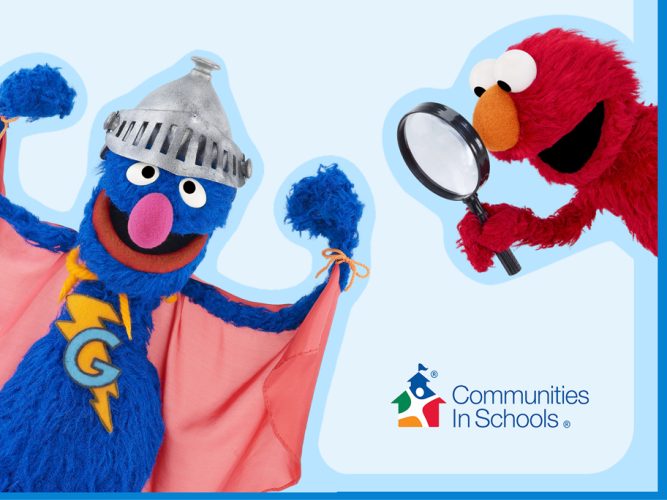 Super Grover and Elmo with a magnifying glass.