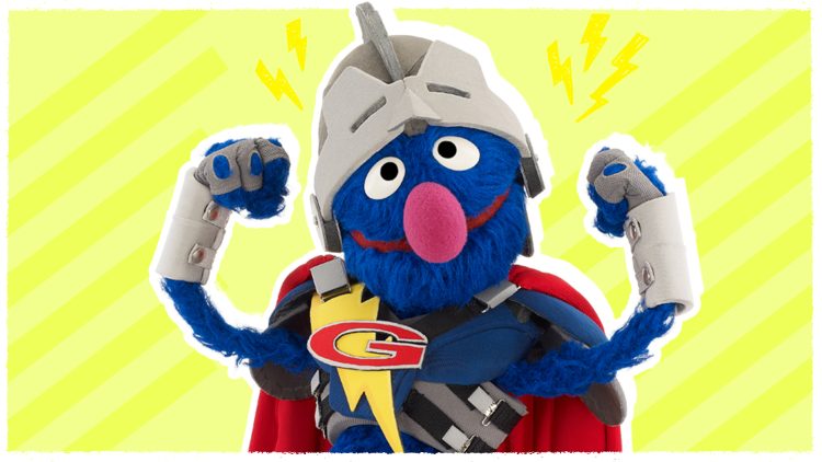 Grover, dressed as a super hero, flexes his biceps.
