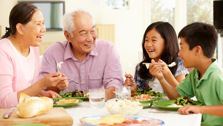 Two grandparents enjoy a meal with their grandchildren.