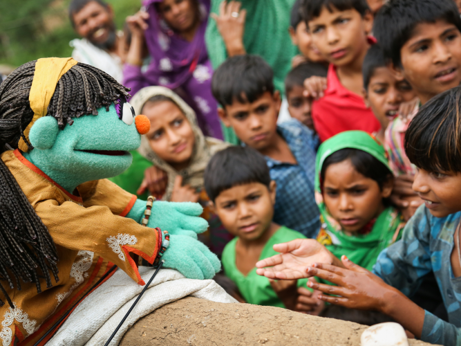 Raya and group of children reaching out to her.