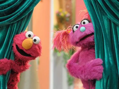 Bel and Elmo peeking from behind a curtain