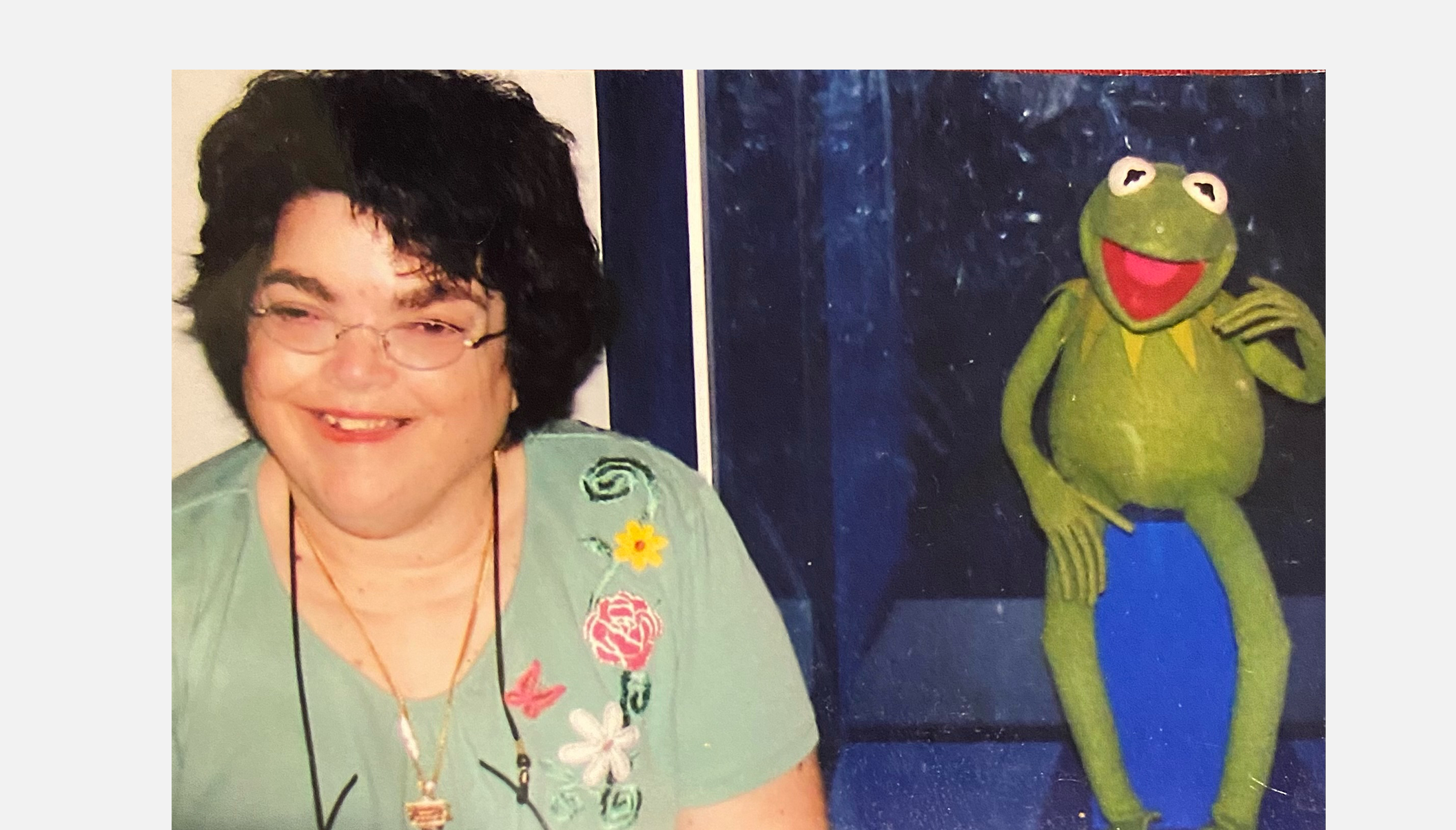 A woman poses with Kermit the Frog