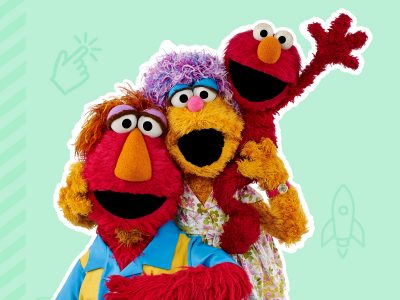 Elmo sits on his moms shoulders while his mom hugs his dad.