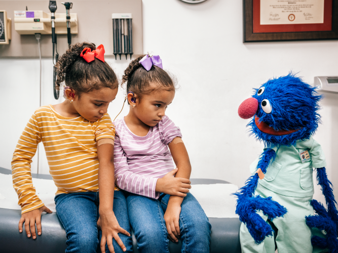 Grover with two kids at a doctors appointment.