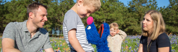 Grover plays with a family in a meadow