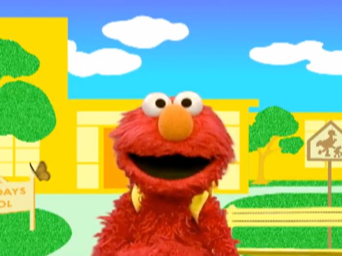 Elmo poses in front of a school wearing a backpack
