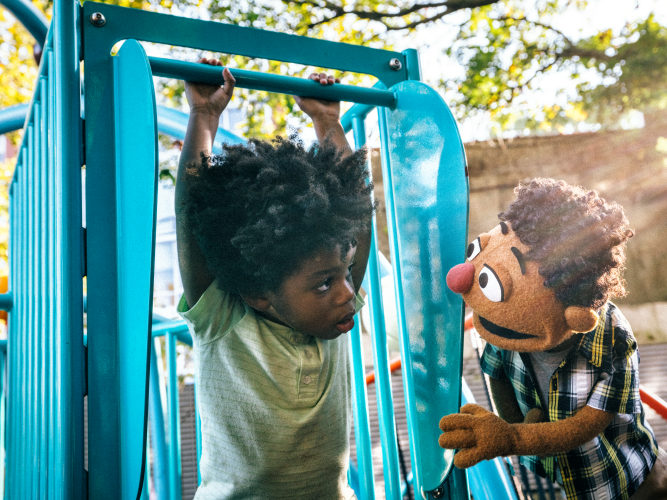 Wes playing with a kid on the playground.