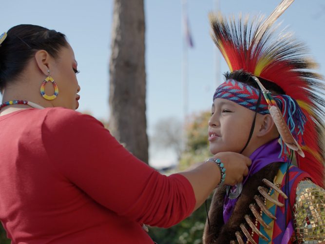 An adult adjusts the headpiece of a child