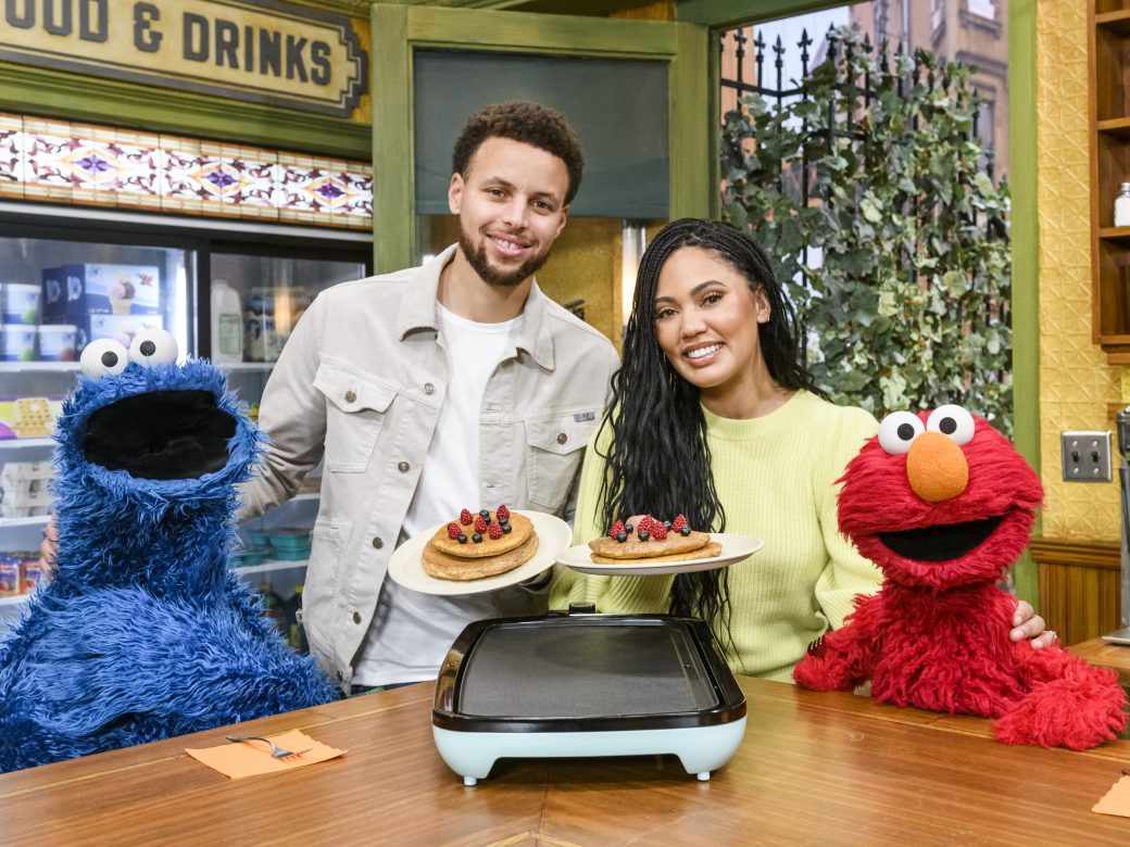 Stephen Curry and Ayesha Curry pose with Cookie Monster and Elmo