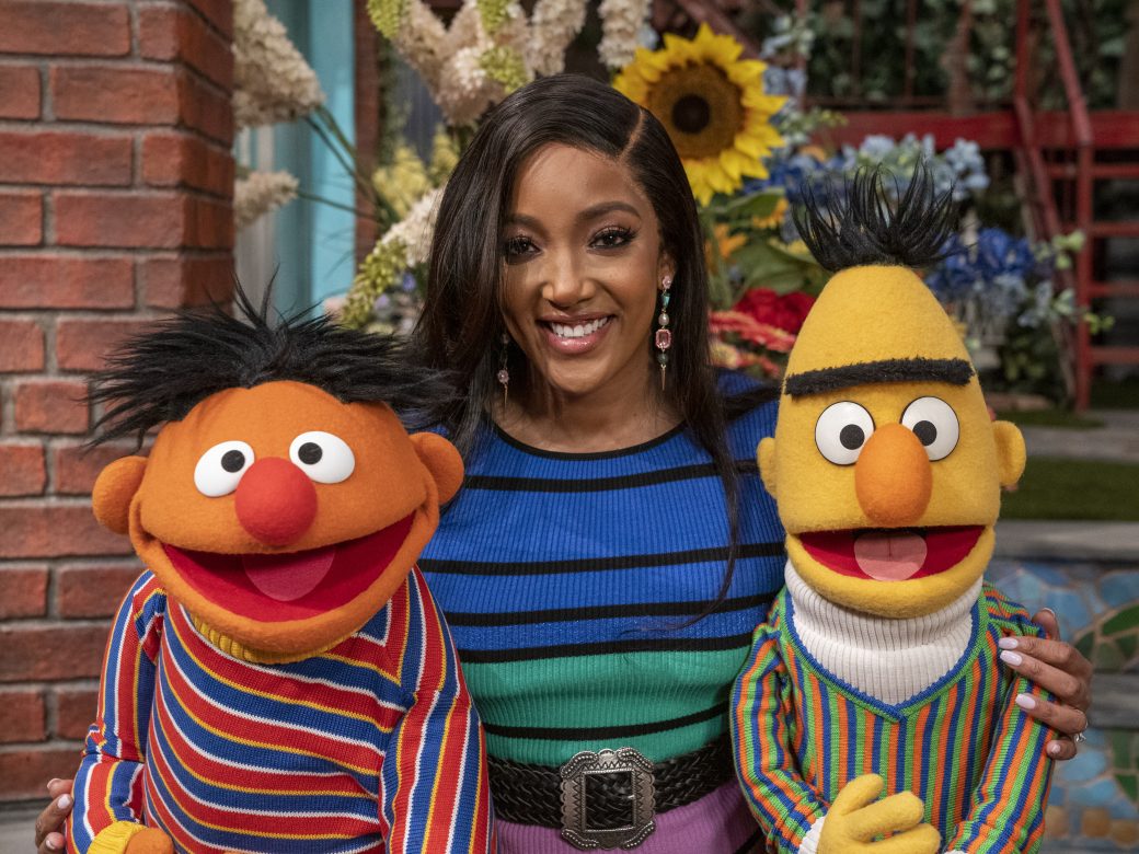 A woman poses with Bert and Ernie