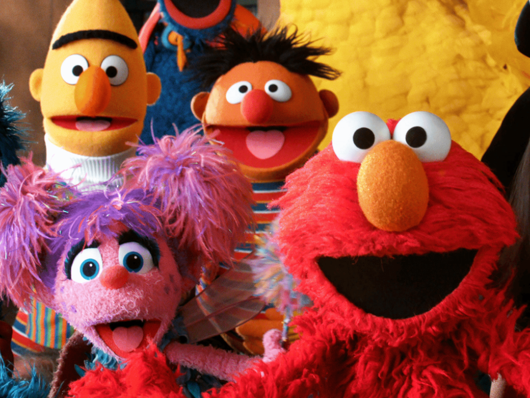 The Muppets of Sesame Street crowd together with a few friends to take a huge group photo.