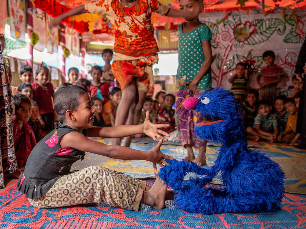 Grover reaching out to a child.