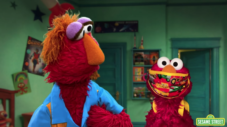 Elmo is with his dad, Louie, wearing his backpack and a facemask