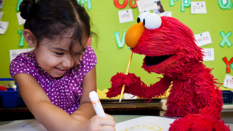 Elmo and a child coloring.