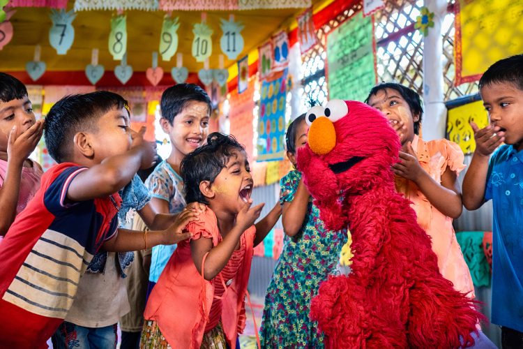 Elmo laughing and playing with children