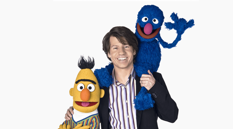Eric poses with his right arm around Bert. Grover sits on Eric's shoudlers.