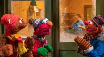 Elmo, Baby bear, and Ernie are dressed for Winter and talk outside in the snow