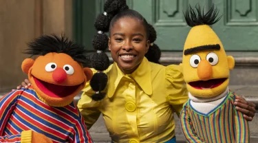 Bert and Ernie pose with Amanda Gorman