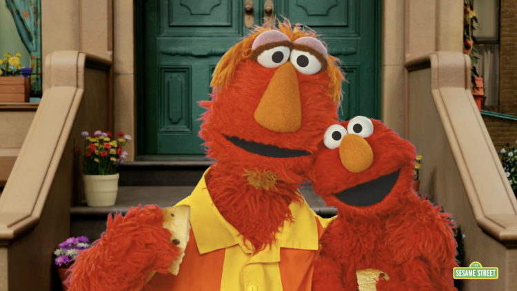 Elmo and his dad share a cookie on the stoop of 123 Sesame.