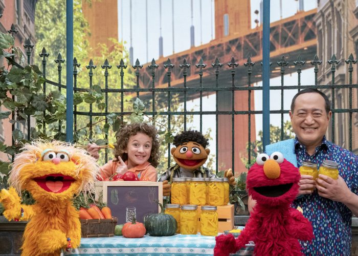 Zoe, Charlie, Tamir, Elmo and Alan gather around a picnic table