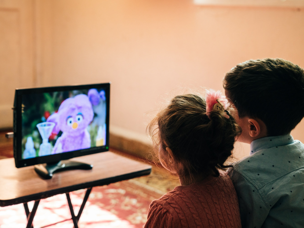 Two kids watching Ahlan SimSim on tv.