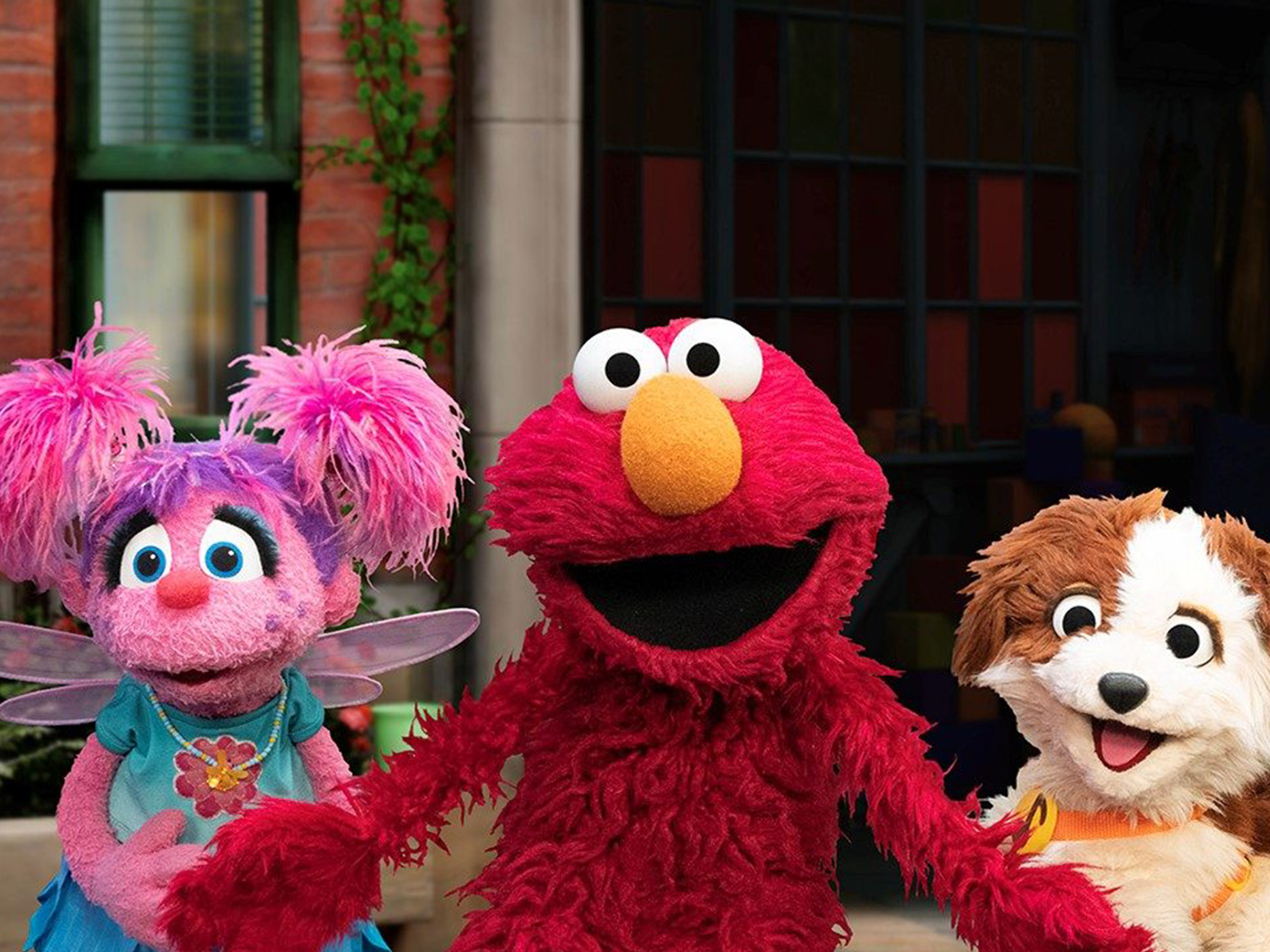 Elmo, Abby, and Tango smile and pose together