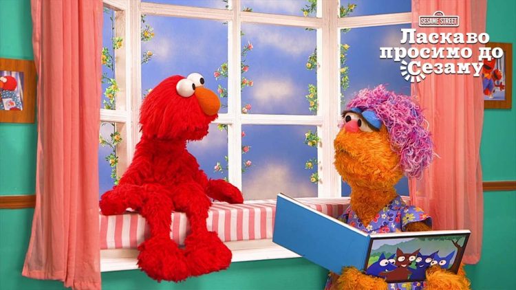 Mae reading a book to Elmo