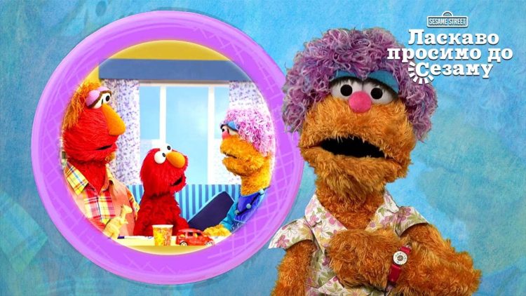 A screenshot of Mae's Minute with a photo of Louie, Elmo, and Mae