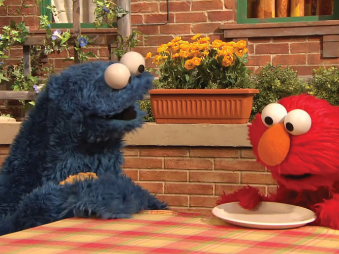 Elmo and Cookie Monster looking at plate.