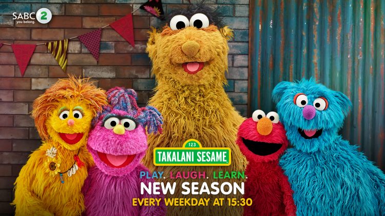 The cast of Takalani Sesame pose together and smile for a picture.