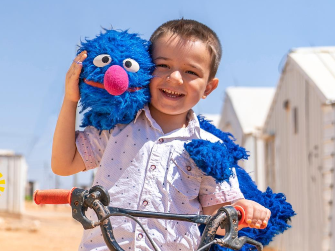 Grover and child on a bicycle.