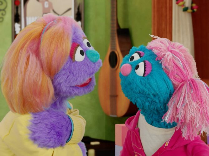An adult Muppet comforts a young, pensive Muppet