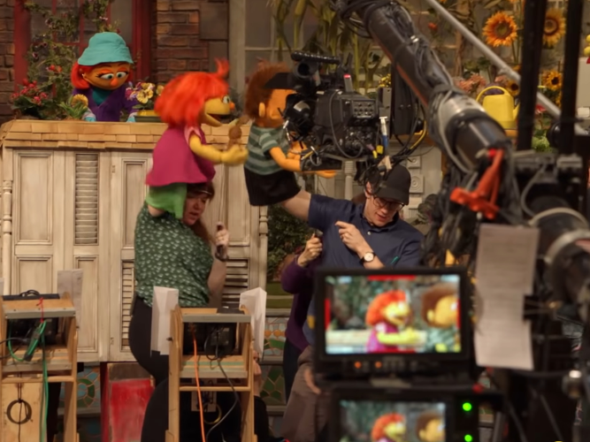 A camera filming Julia on Sesame Street set.