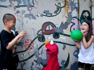 Children playing with Elmo
