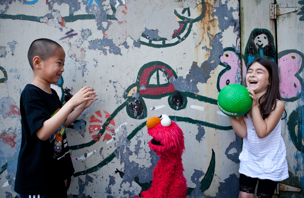 Children playing with Elmo