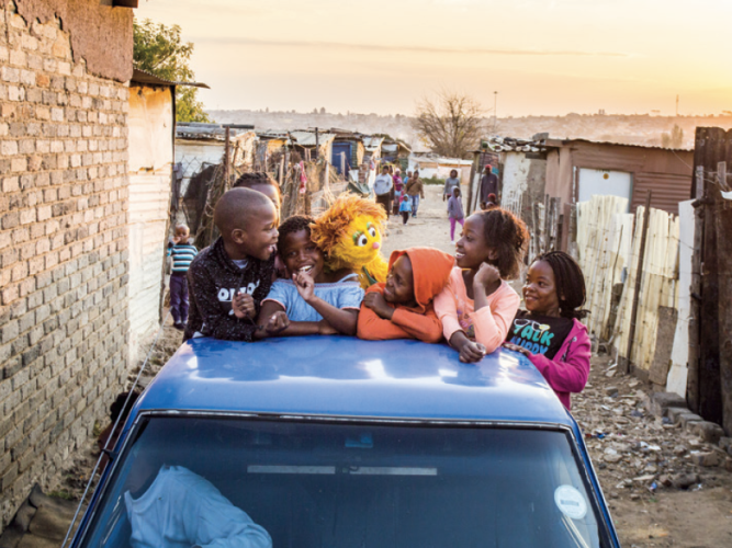 Children leaning on a car.
