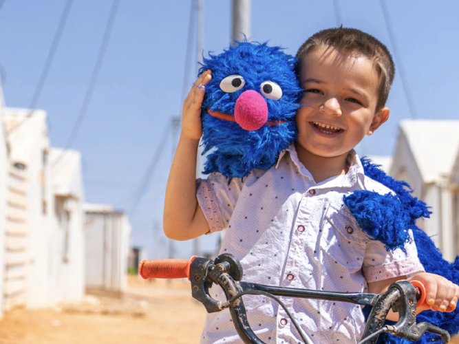 Grover and a child on a bike.