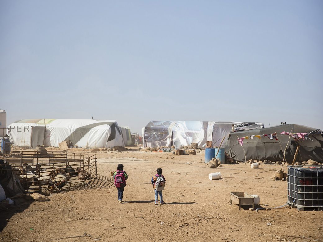 Children walking outside a refugee camp.
